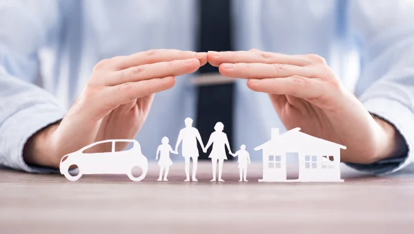 Main protégeant une famille, une voiture et une maison, symbolisant les protections offertes par l’assurance auto et habitation.